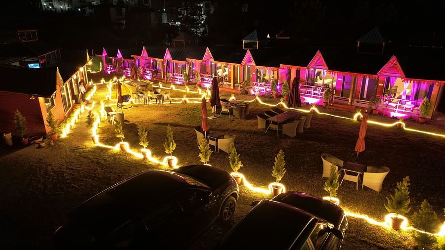 Sol Glow Resort, Nainital Nainital Two cars facing a set of cottage rooms, fillwed with glowy lights during the night